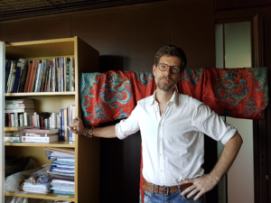 Philippe Charlier dans son bureau du musée du quai Branly - Jacques Chirac (à l’arrière-plan, un costume d’exorcisme taoïste de la fin du 19e siècle) ©UVSQ